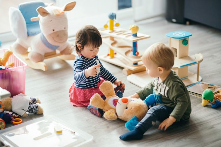 cute little girl and boy playing with toys by the home